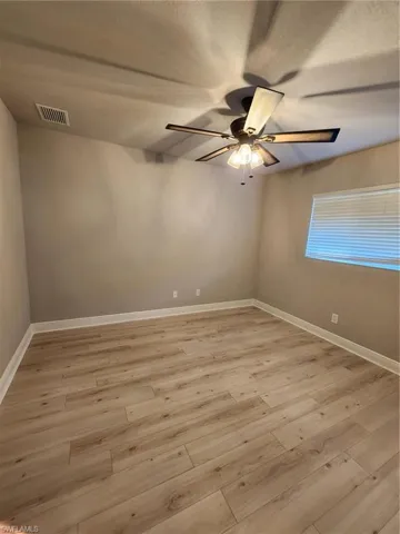 Spare room with light wood-type flooring and ceiling fan