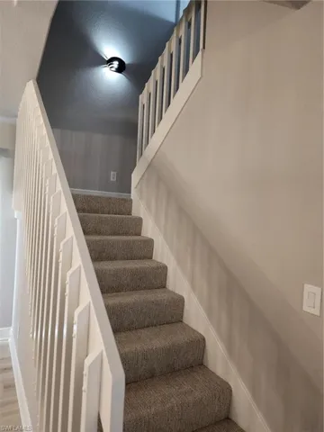 Staircase featuring hardwood / wood-style flooring