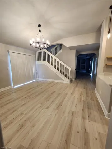 Spare room featuring an inviting chandelier and hardwood / wood-style floors