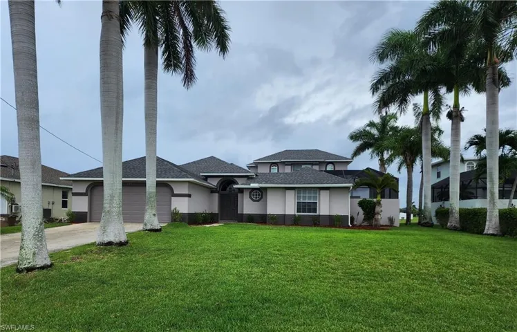 View of front of home with a garage and a front lawn
