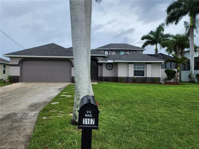View of front facade featuring a front lawn and a garage