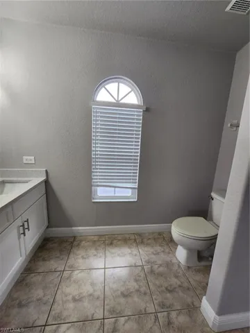 Bathroom with tile floors, vanity, and toilet
