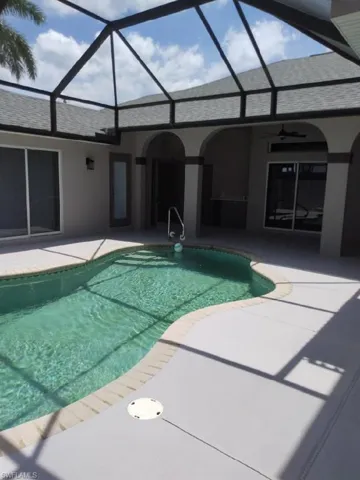View of pool with a patio, a lanai, and ceiling fan