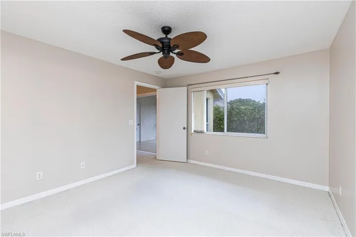 Carpeted spare room with a textured ceiling and ceiling fan