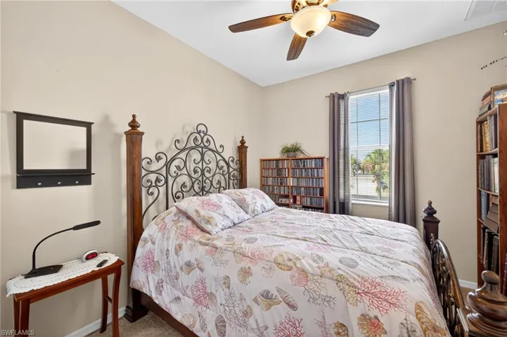 Interior room featuring a ceiling fan with integrated lighting, a window with horizontal blinds and curtains, and neutral wall paint