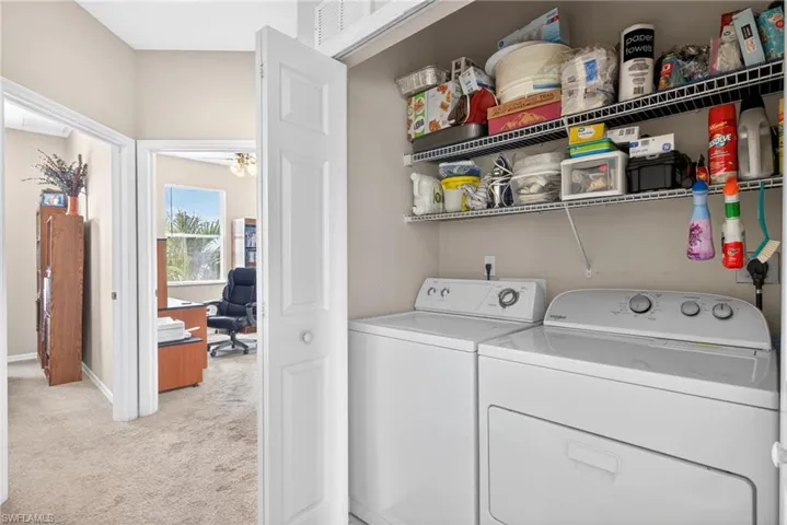 Integrated laundry area featuring a white top-load washing machine and front-load dryer