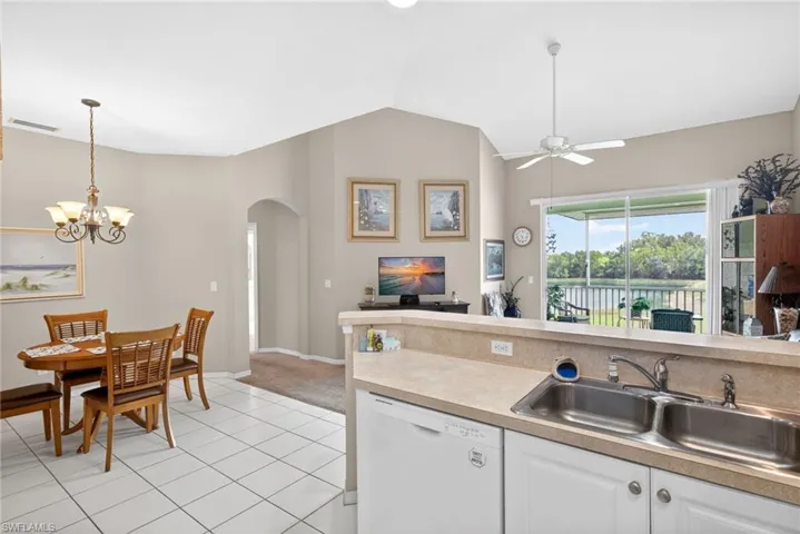 Kitchen featuring white cabinetry, light-toned countertops, and a dual basin stainless steel sink