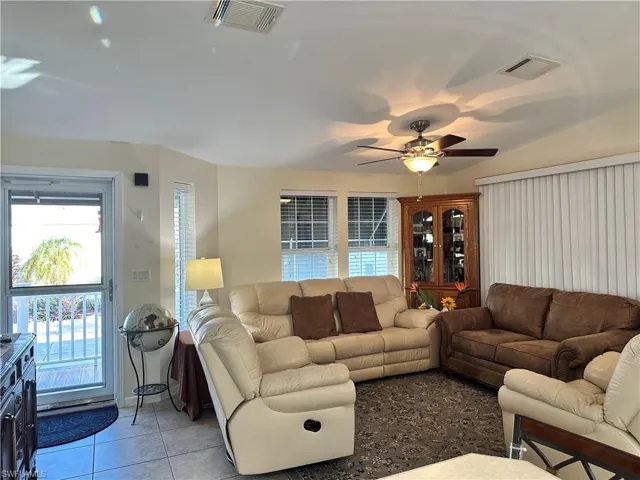 Tiled living room with a ceiling fan