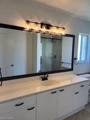 Bathroom featuring walk in shower and vanity