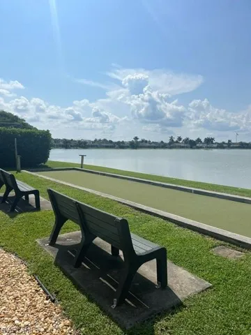 Surrounding community featuring a water view and a yard