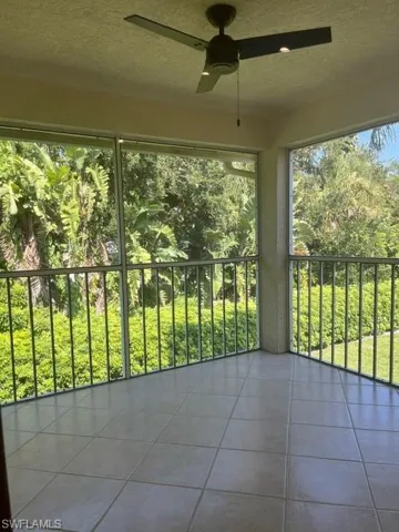 Unfurnished sunroom featuring ceiling fan