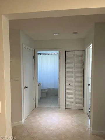 Hall featuring a textured ceiling and light tile patterned floors