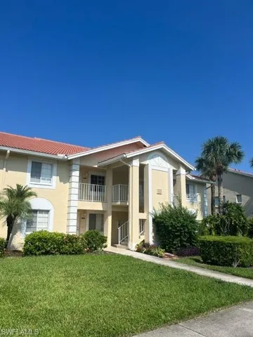 View of front facade with a balcony and a front yard