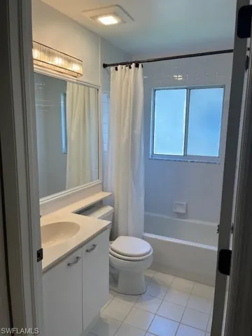 Full bathroom featuring tile patterned floors, vanity, shower / bath combination with curtain, and toilet