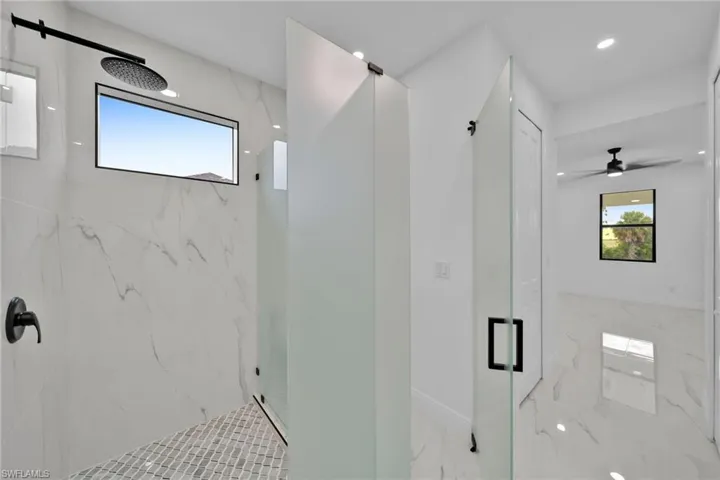 Bathroom with ceiling fan and an enclosed shower