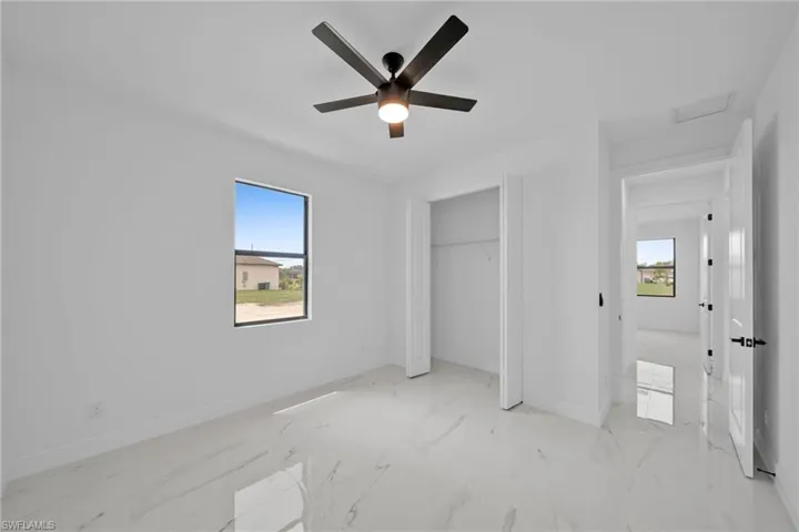 Unfurnished bedroom featuring ceiling fan and a closet