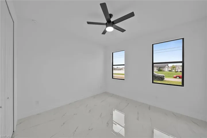 Empty room featuring a wealth of natural light and ceiling fan