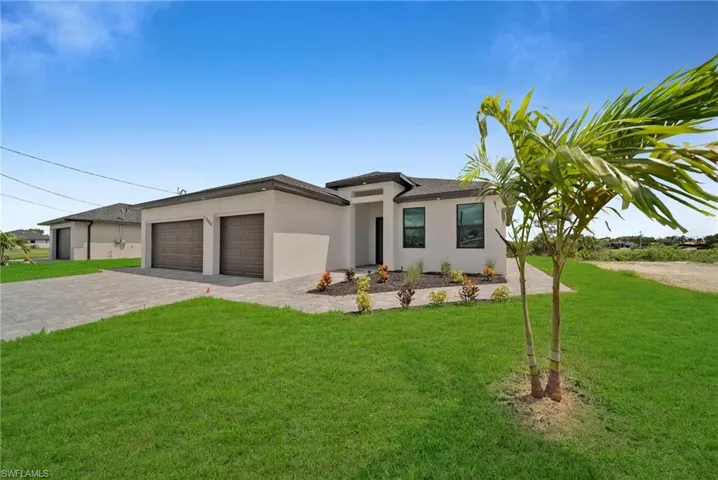 View of front of house featuring a front lawn and a garage