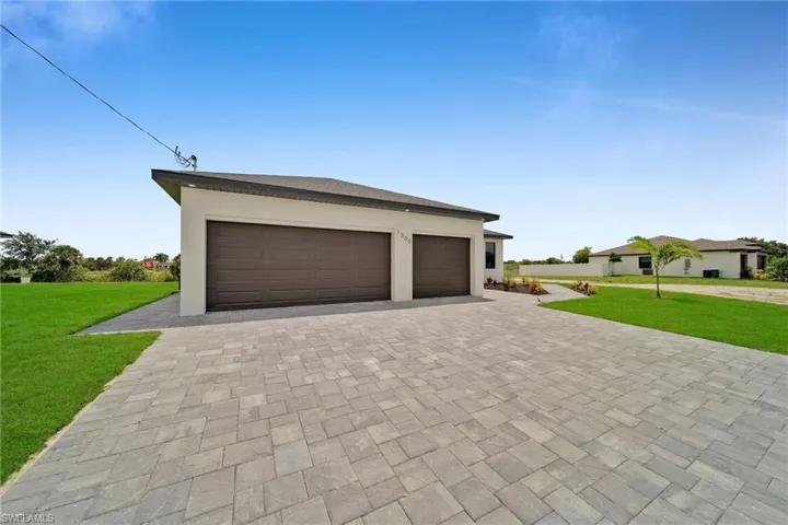 Garage featuring a lawn