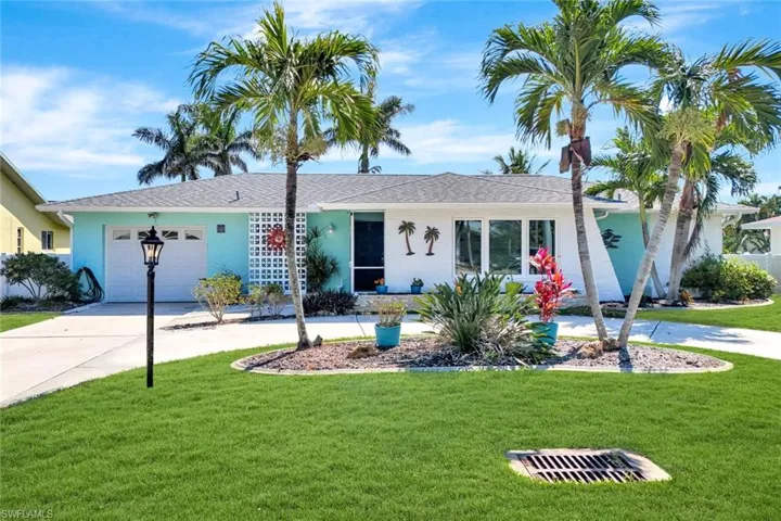Ranch-style home featuring stucco siding, an attached garage, concrete driveway, and a front yard
