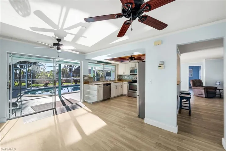 Kitchen featuring appliances with stainless steel finishes, white cabinetry, crown molding, and a ceiling fan
