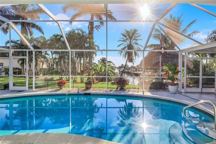 Pool featuring glass enclosure and a patio