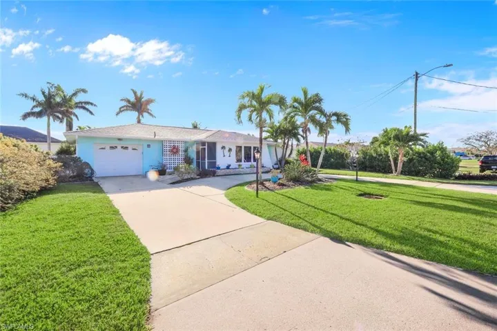 Ranch-style house featuring stucco siding, a front yard, concrete driveway, and an attached garage
