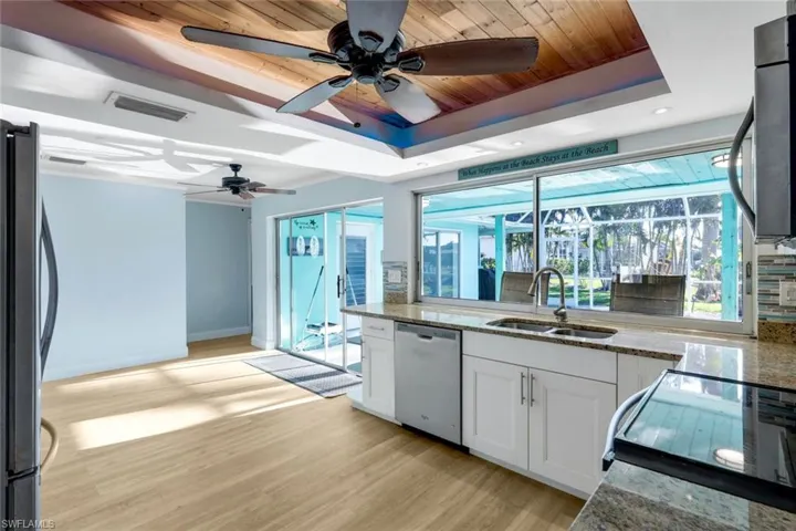 Kitchen featuring visible vents, a sink, a tray ceiling, white cabinetry, and appliances with stainless steel finishes