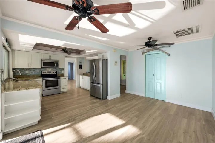 Kitchen featuring tasteful backsplash, visible vents, ornamental molding, appliances with stainless steel finishes, and a sink
