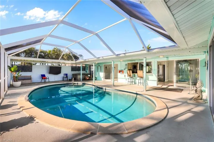 Outdoor pool featuring glass enclosure and a patio area