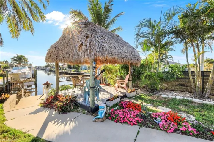 View of patio / terrace with a water view, boat lift, a dock, and fence