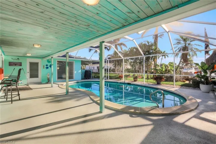 Outdoor pool featuring glass enclosure and a patio