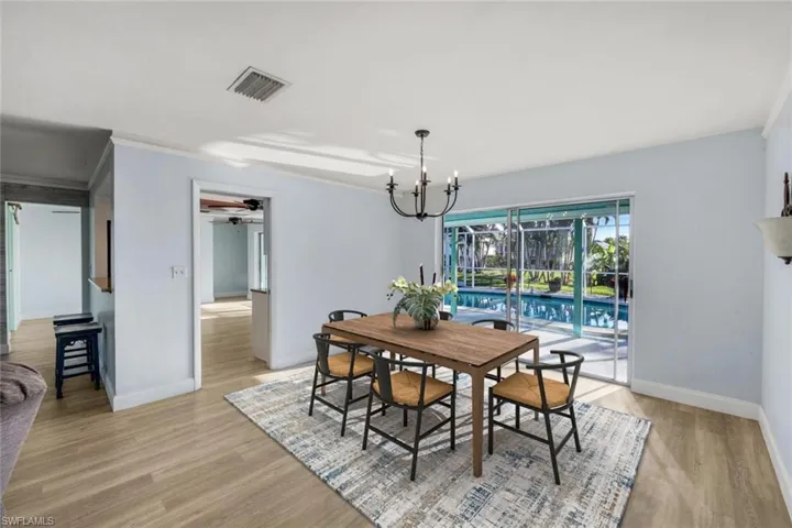 Dining space featuring visible vents, ceiling fan with notable chandelier, baseboards, and light wood-style floors