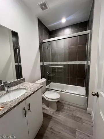 Full bathroom featuring combined bath / shower with glass door and vanity