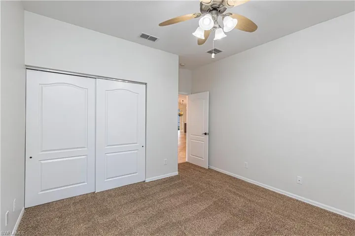 Unfurnished bedroom with baseboards, visible vents, a closet, and carpet
