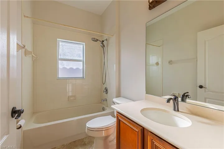 Bathroom featuring toilet, vanity, and shower / washtub combination