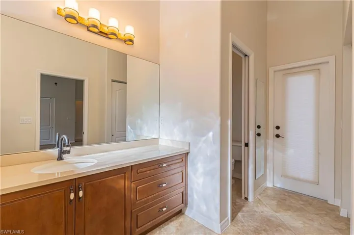 Bathroom with toilet, tile patterned flooring, and vanity