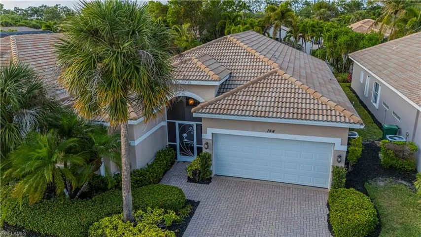View of front facade featuring a tile roof, a garage, decorative driveway, and stucco siding