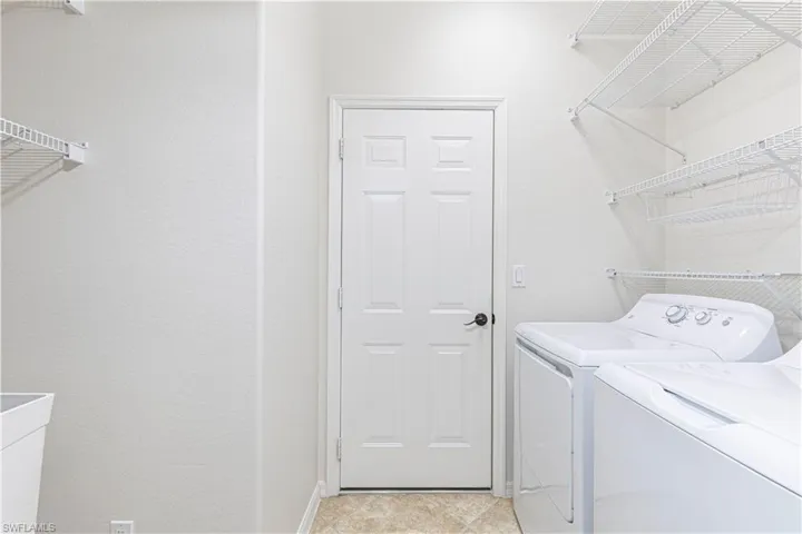 Laundry room with baseboards, laundry area, and washer and dryer