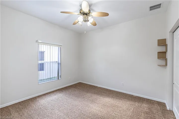 Unfurnished room featuring baseboards, carpet flooring, ceiling fan, and visible vents