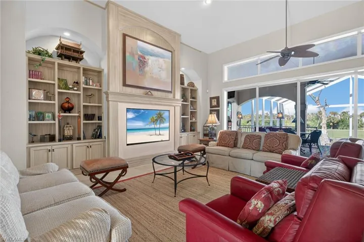 Living area featuring built in shelves, ceiling fan, and a sunroom