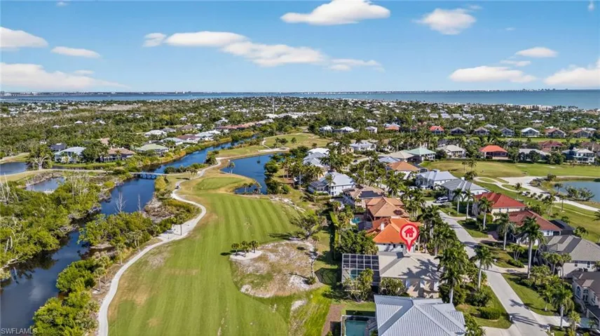 Aerial view of residential area featuring a nearby body of water and a local golf course