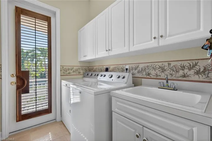 Laundry room featuring cabinet space, washing machine and clothes dryer, and light tile patterned floors
