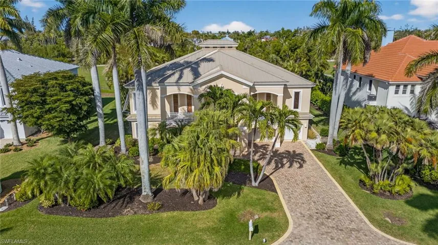 View of front of house with a front yard, decorative driveway, and stucco siding