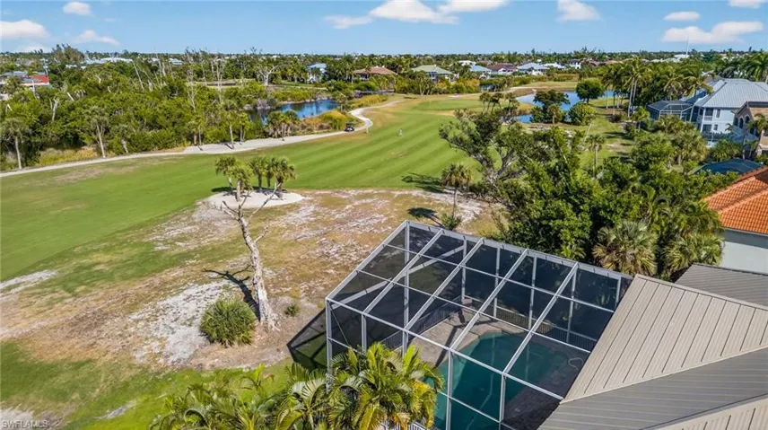 Aerial perspective of suburban area featuring a golf course and a large body of water