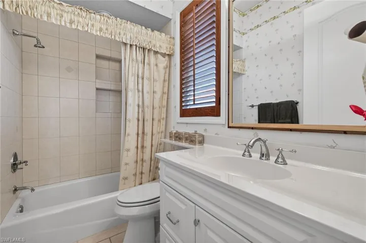 Bathroom with vanity and shower / tub combo with curtain