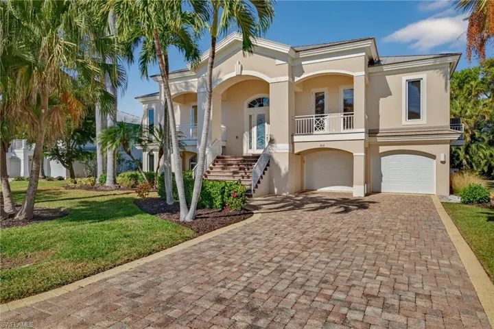 Mediterranean / spanish home with a balcony, stucco siding, decorative driveway, a front lawn, and an attached garage