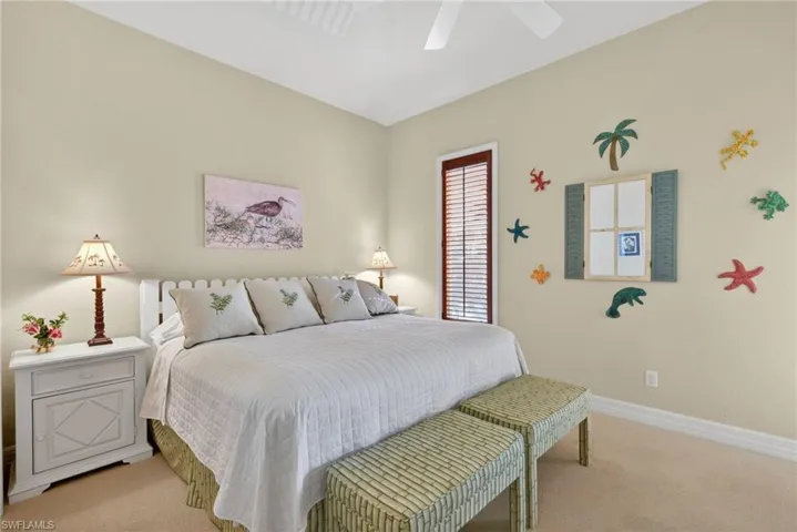 Bedroom with light colored carpet and a ceiling fan