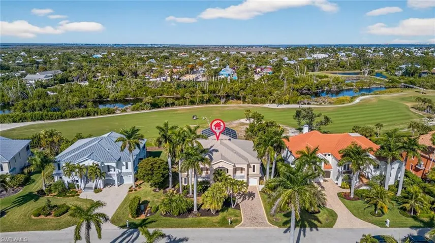 Aerial perspective of suburban area with a golf club and a large body of water