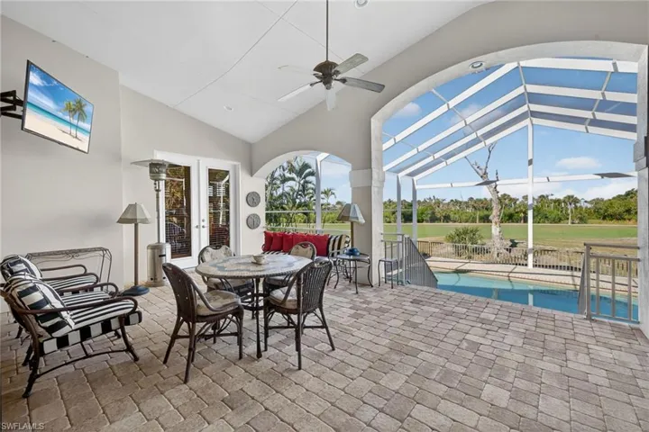 View of patio / terrace featuring ceiling fan, a sunroom, outdoor dining space, and glass enclosure